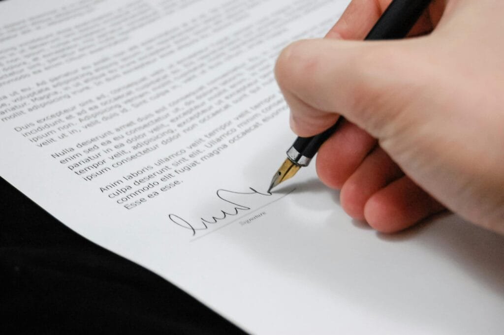 Close up of a hand signing a legal document with a fountain pen symbolizing signature and agreement